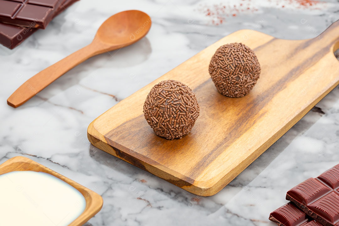 Brigadeiros sobre tábua de madeira sobremesa doce brasileira.