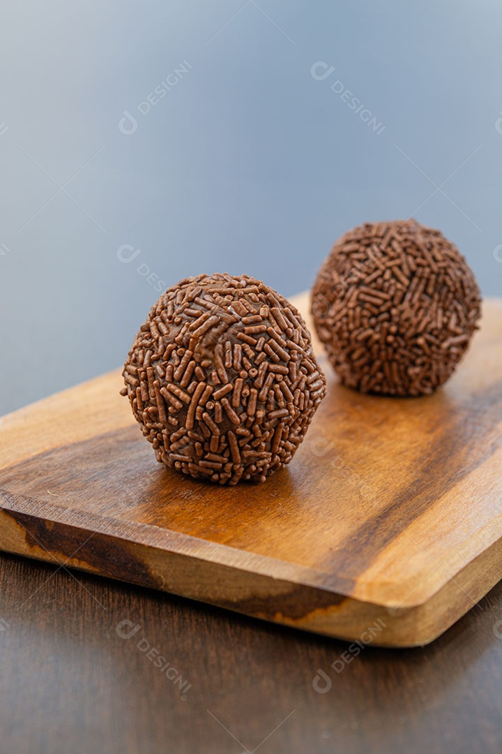 Brigadeiros sobre tábua de madeira sobremesa doce brasileira.