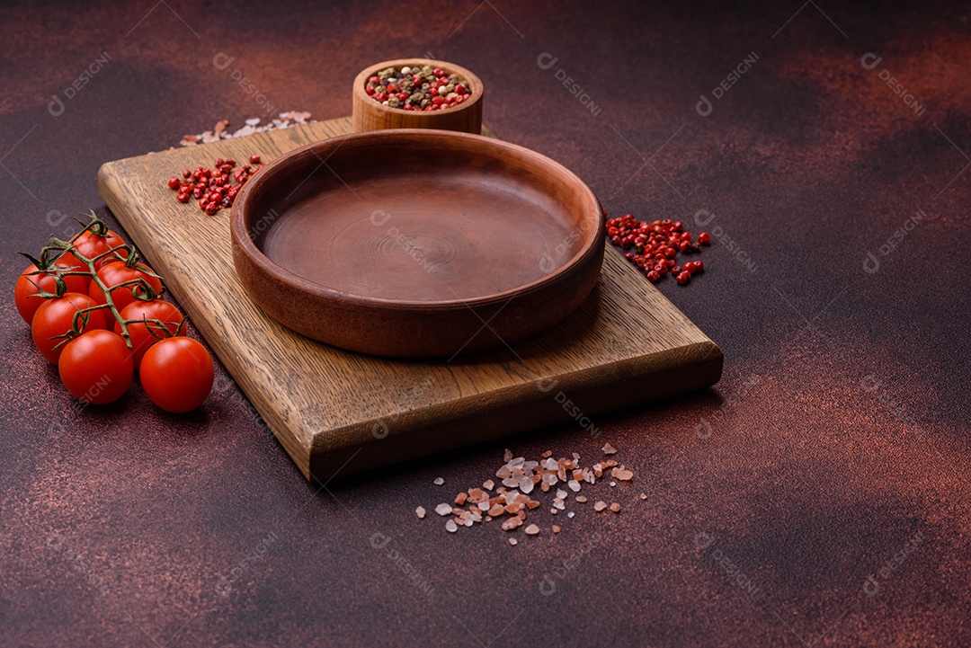 Placa redonda de cerâmica vazia em fundo de concreto texturizado escuro. Talheres, preparação para o jantar