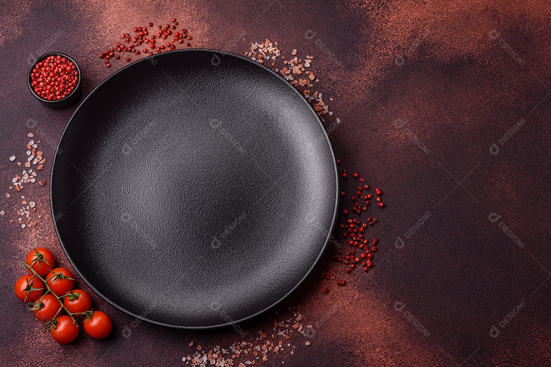 Placa redonda de cerâmica vazia em fundo de concreto texturizado escuro. Talheres, preparação para o jantar