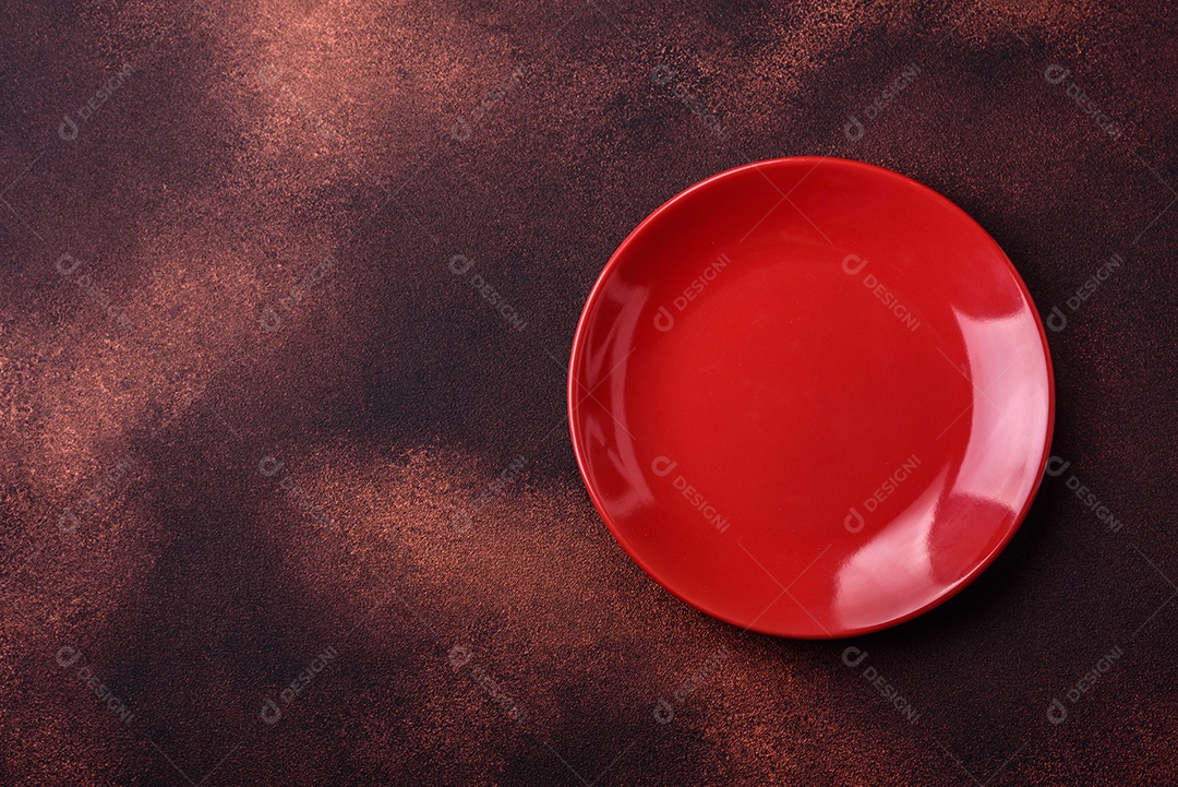 Placa redonda de cerâmica vazia em fundo de concreto texturizado escuro. Talheres, preparação para o jantar