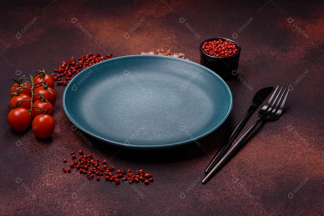 Placa redonda de cerâmica vazia em fundo de concreto texturizado escuro. Talheres, preparação para o jantar