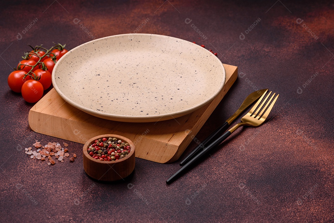 Placa redonda de cerâmica vazia em fundo de concreto texturizado escuro. Talheres, preparação para o jantar