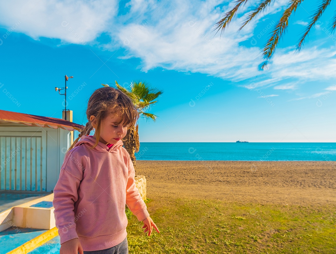 Uma garotinha linda sobre fundo de praia