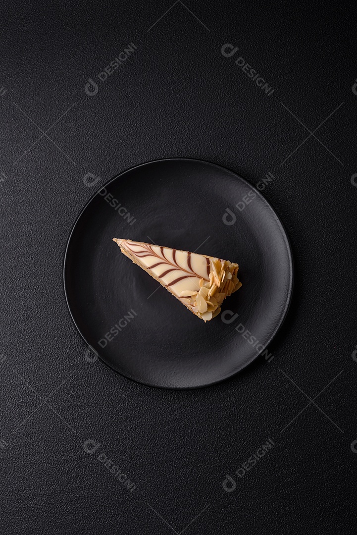 Pedaço de delicioso bolo esterhazy doce com nozes e creme sobre um fundo escuro de concreto