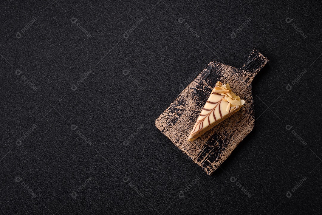 Pedaço de delicioso bolo esterhazy doce com nozes e creme sobre um fundo escuro de concreto