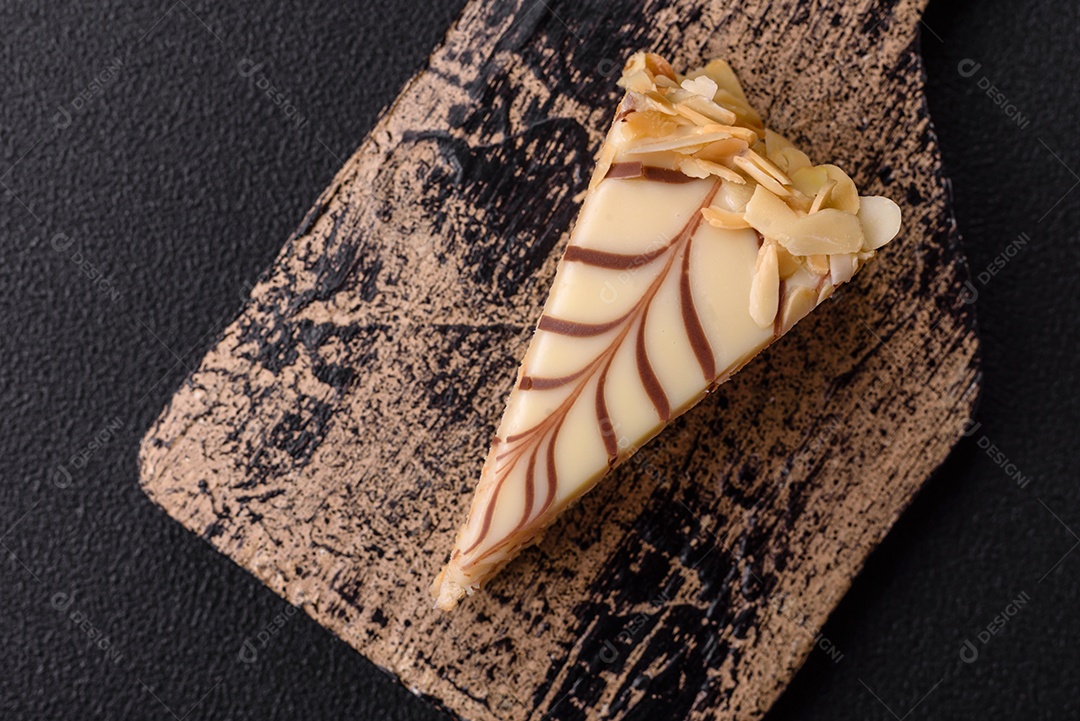 Pedaço de delicioso bolo esterhazy doce com nozes e creme sobre um fundo escuro de concreto