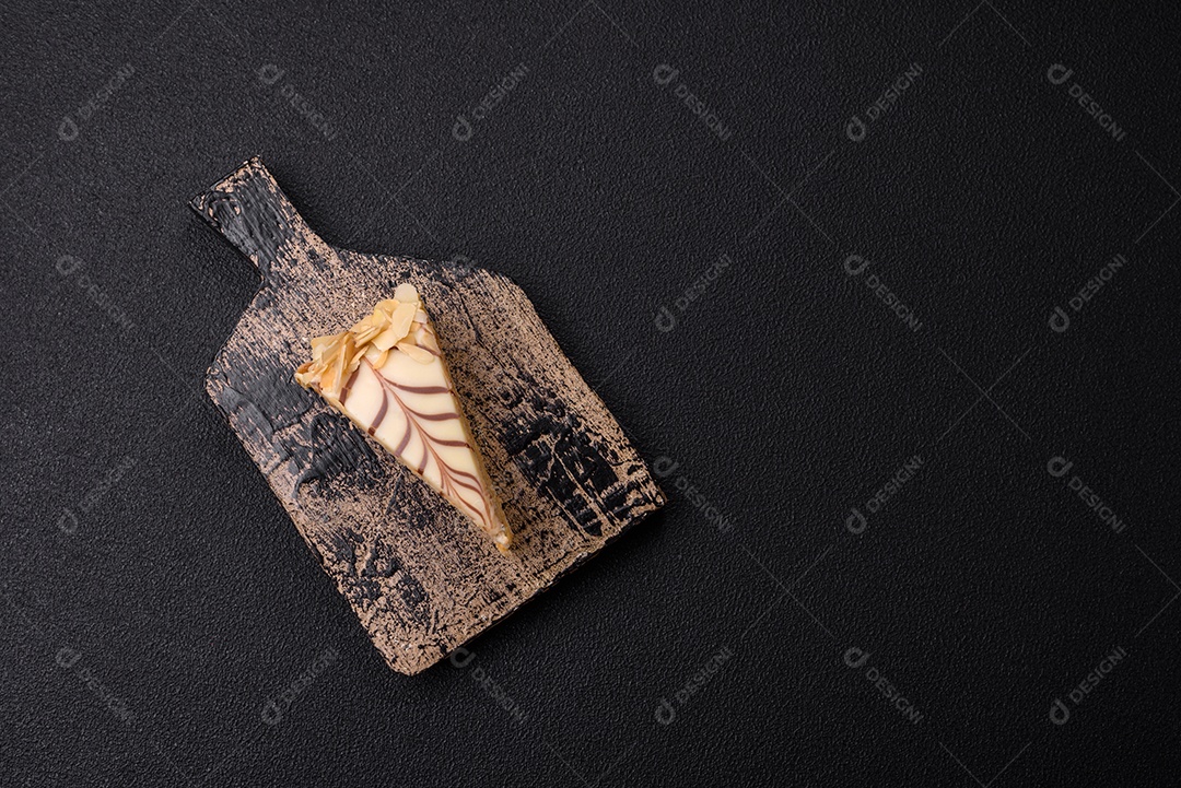 Pedaço de delicioso bolo esterhazy doce com nozes e creme sobre um fundo escuro de concreto