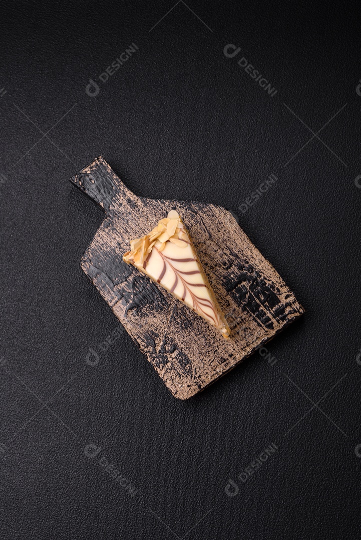 Pedaço de delicioso bolo esterhazy doce com nozes e creme sobre um fundo escuro de concreto