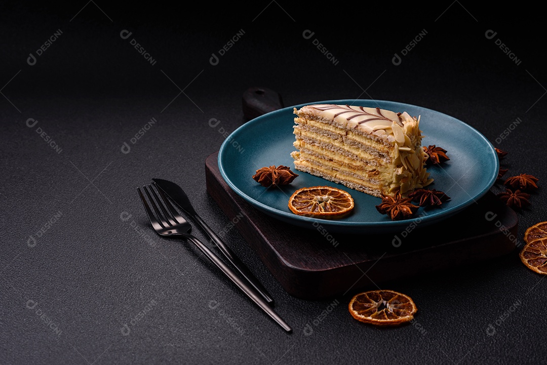 Pedaço de delicioso bolo esterhazy doce com nozes e creme sobre um fundo escuro de concreto