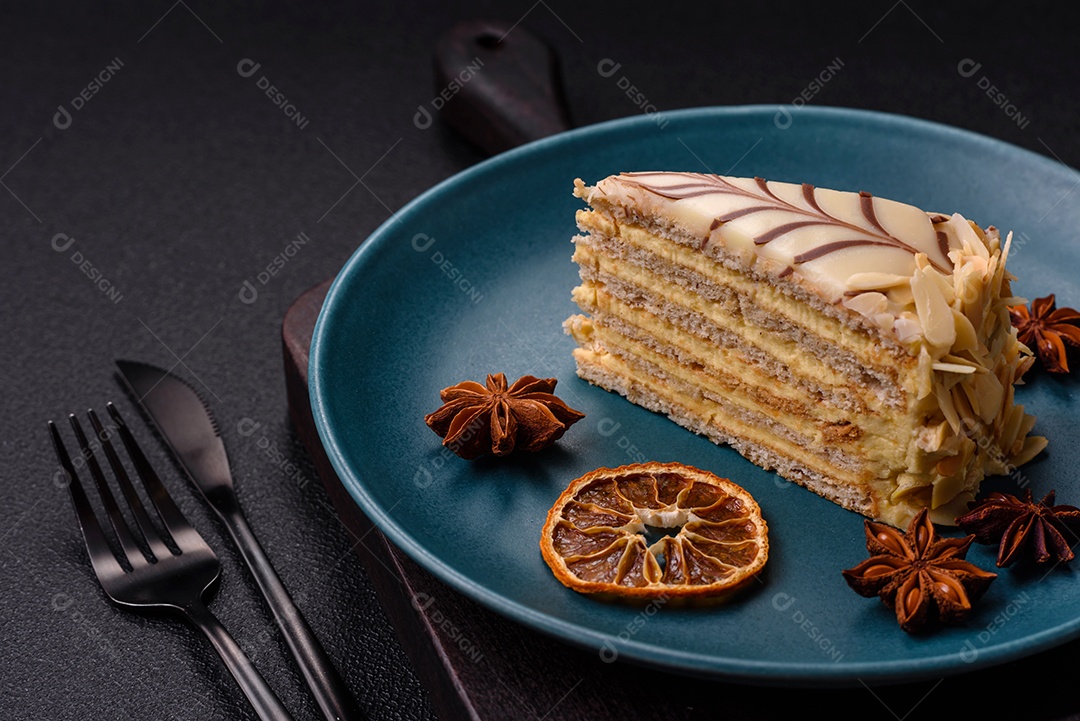 Pedaço de delicioso bolo esterhazy doce com nozes e creme sobre um fundo escuro de concreto