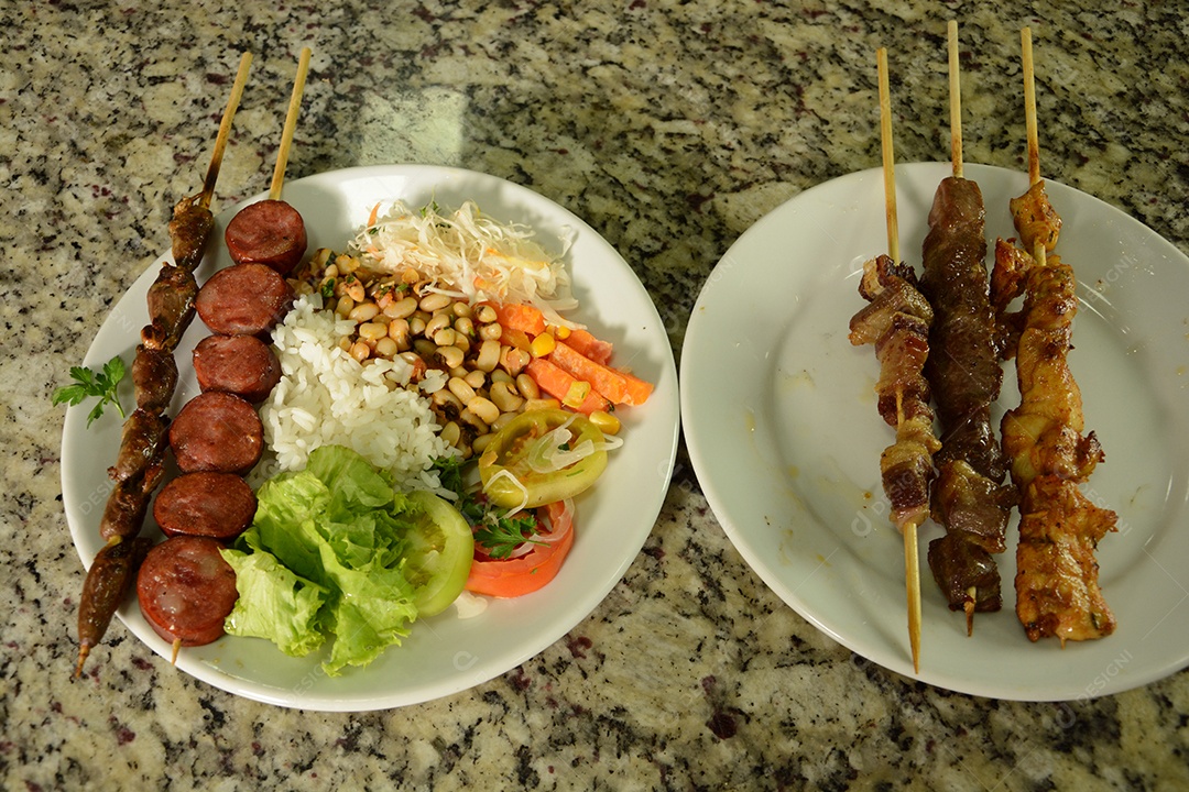 Prato delicioso tradicional com arroz espetinho e saladas