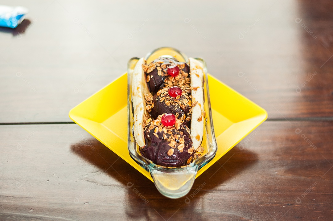 Bandeja amarela com banana split com açaí