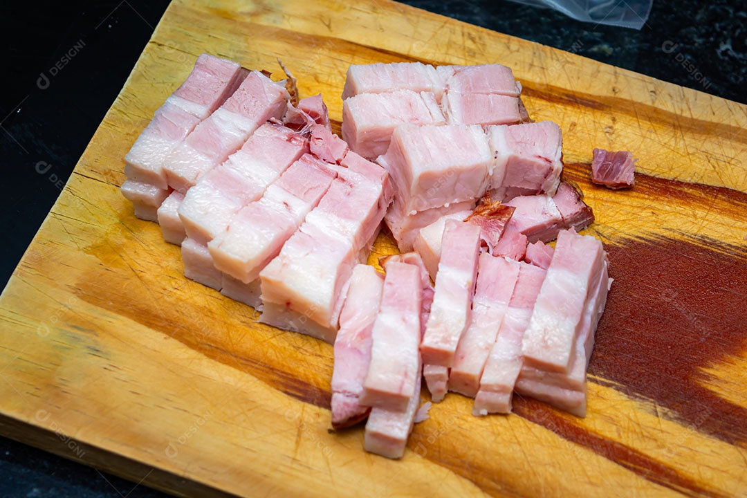 Bacon cortado em cubos na tábua de madeira
