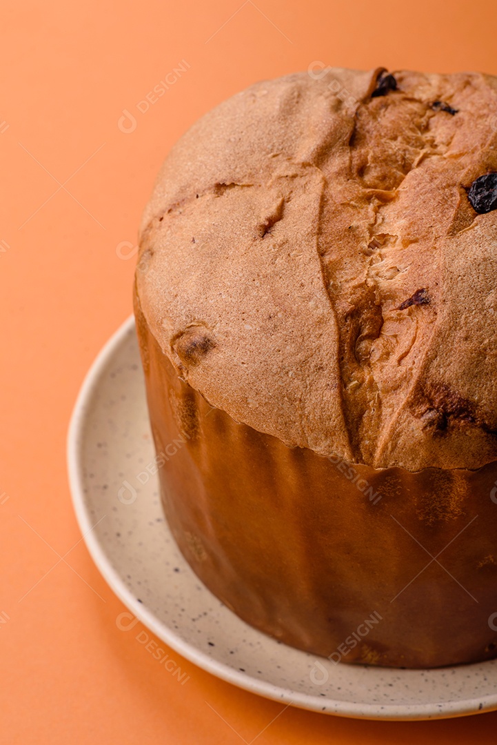 Delicioso bolo de panetone doce com raspas e passas em um prato de cerâmica. Atributo da tabela de feriados