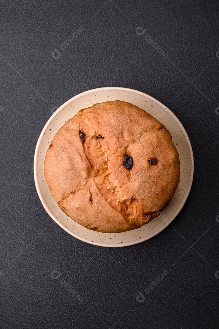 Delicioso bolo de panetone doce com raspas e passas em um prato de cerâmica. Atributo da tabela de feriados