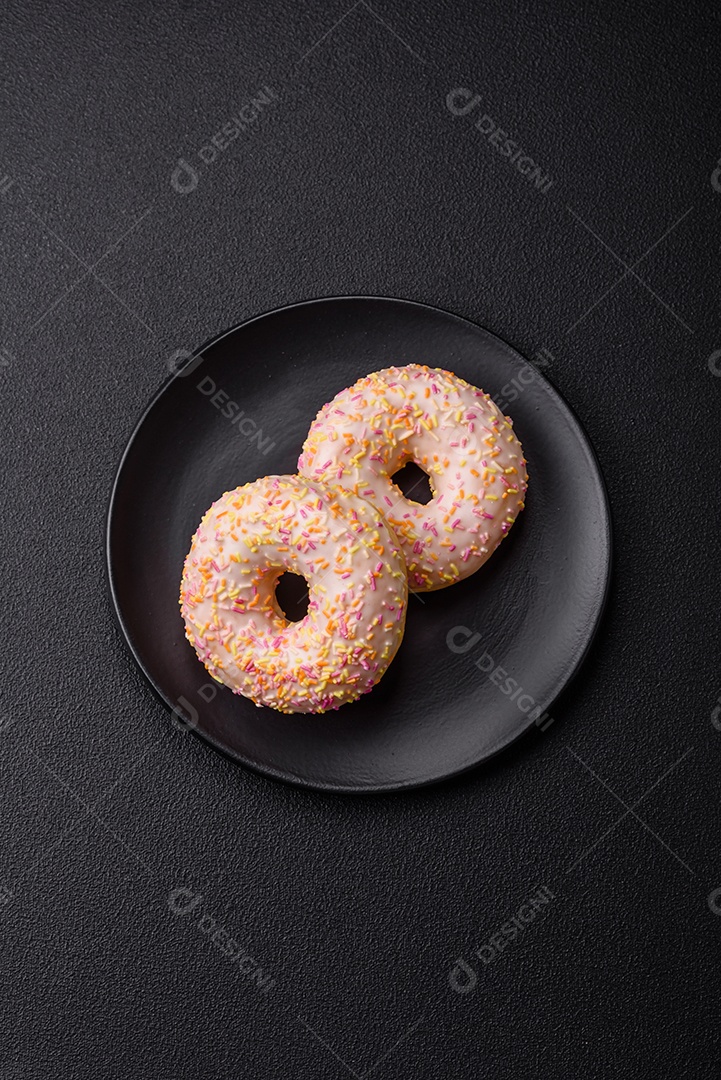 Deliciosos donuts doces e brilhantes com creme em um fundo liso. Atributo da tabela de feriados