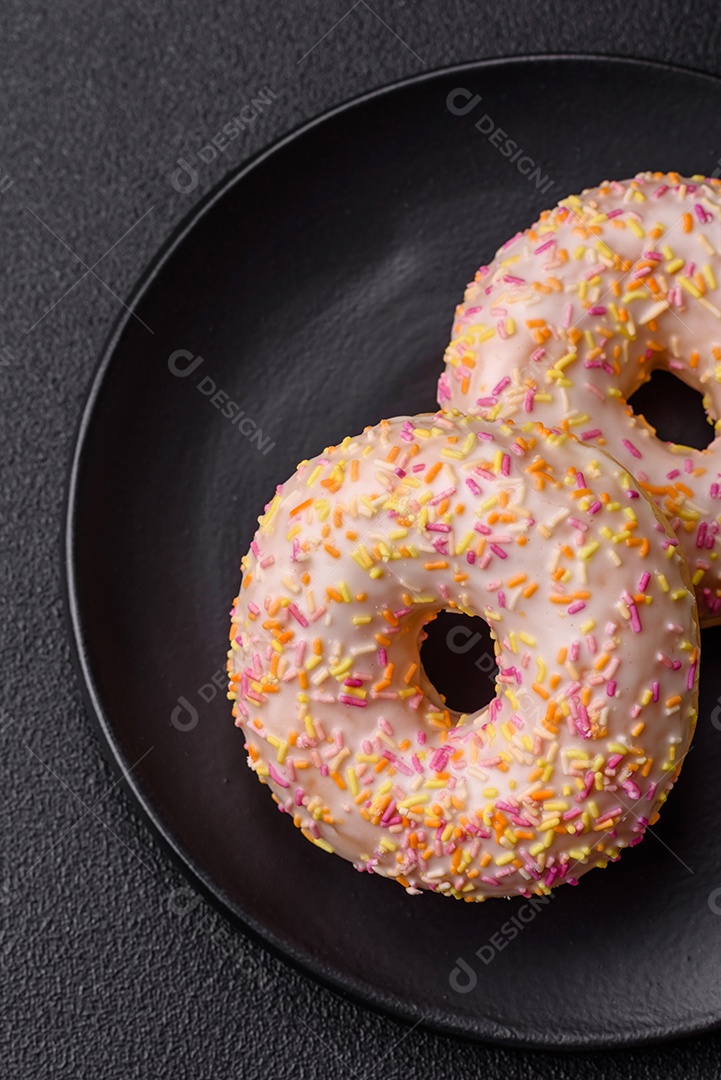 Deliciosos donuts doces e brilhantes com creme em um fundo liso. Atributo da tabela de feriados