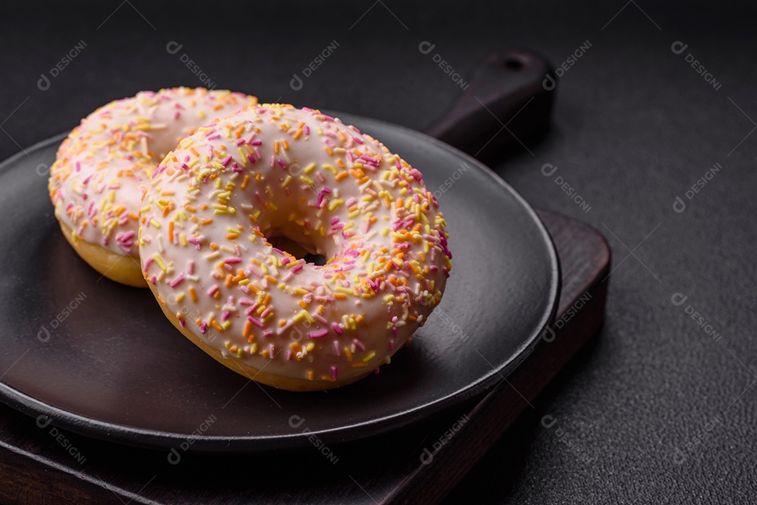 Deliciosos donuts doces e brilhantes com creme em um fundo liso. Atributo da tabela de feriados