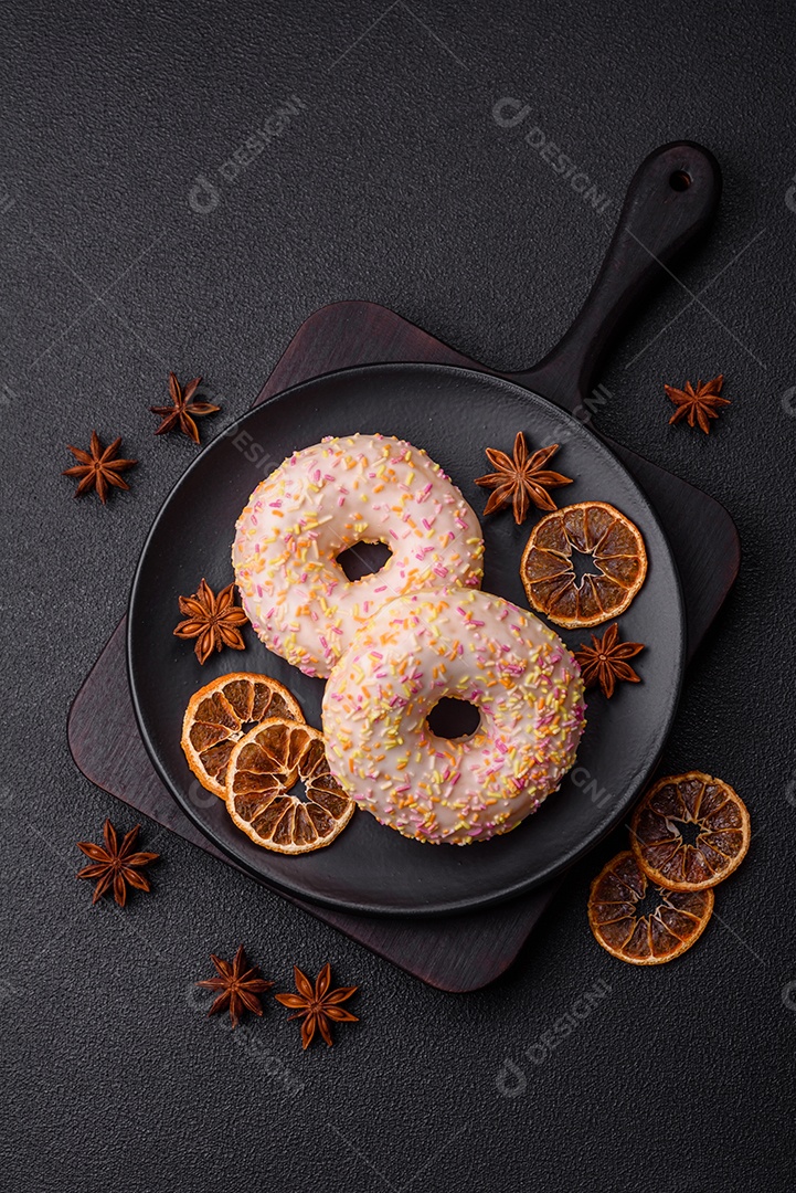 Deliciosos donuts doces e brilhantes com creme em um fundo liso. Atributo da tabela de feriados