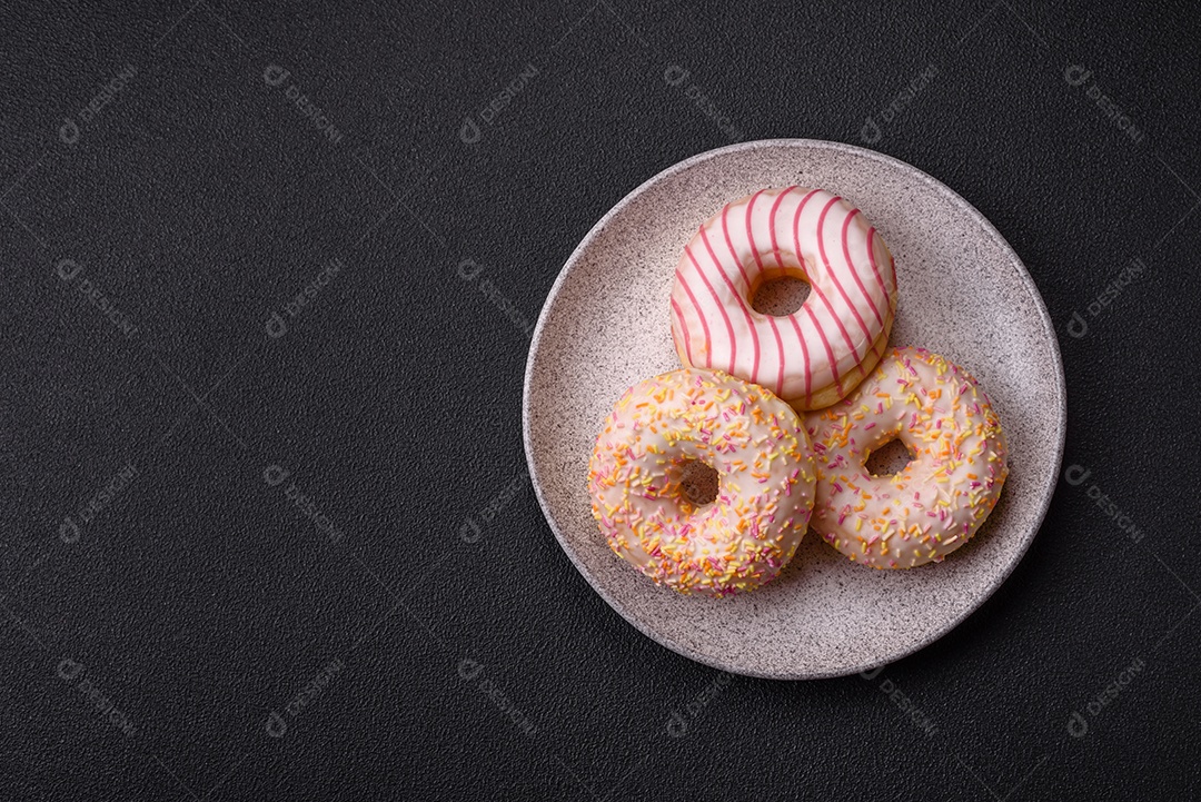 Deliciosos donuts doces e brilhantes com creme em um fundo liso. Atributo da tabela de feriados
