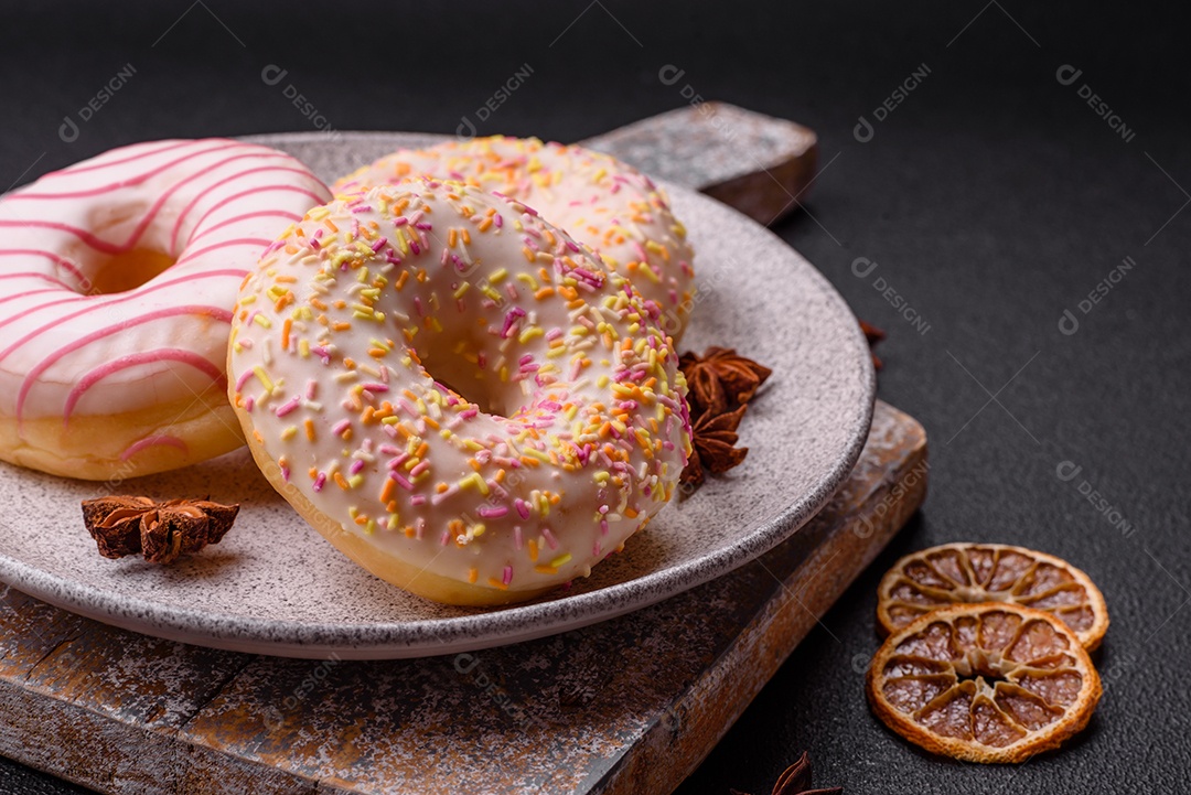 Deliciosos donuts doces e brilhantes com creme em um fundo liso. Atributo da tabela de feriados