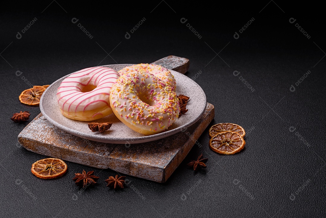 Deliciosos donuts doces e brilhantes com creme em um fundo liso. Atributo da tabela de feriados