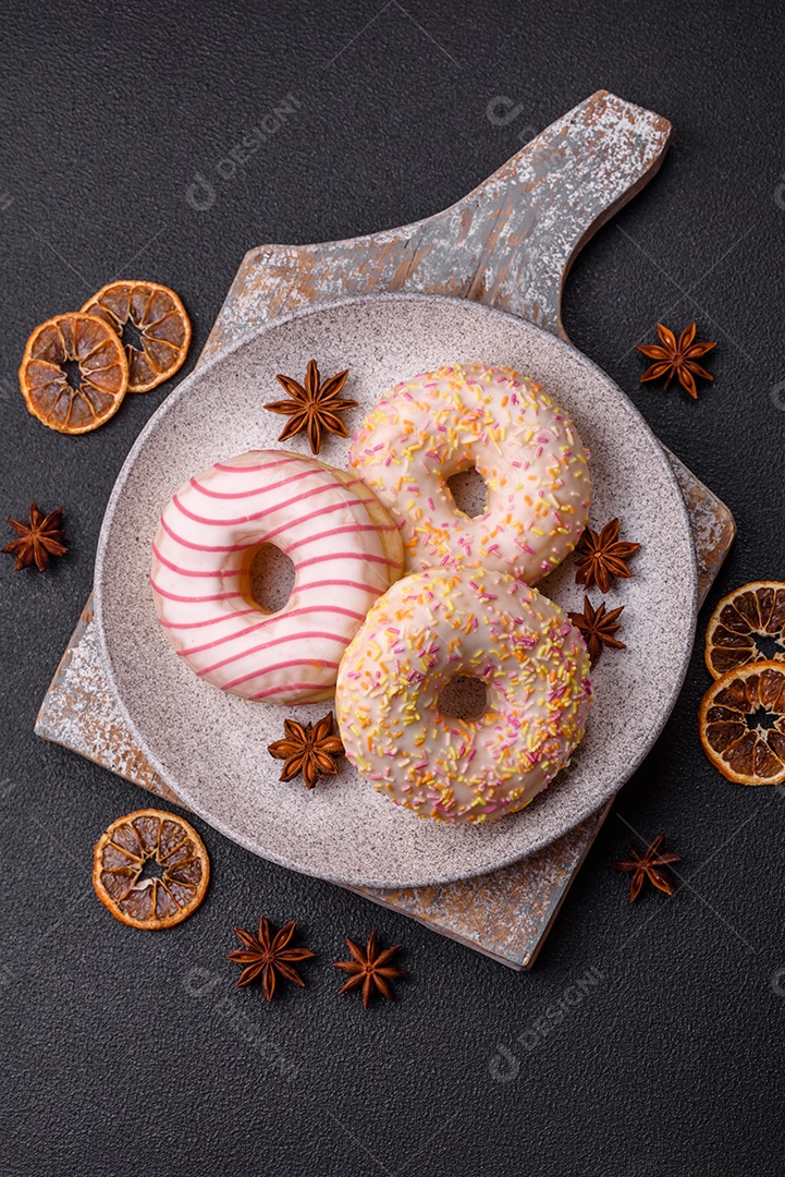 Deliciosos donuts doces e brilhantes com creme em um fundo liso. Atributo da tabela de feriados