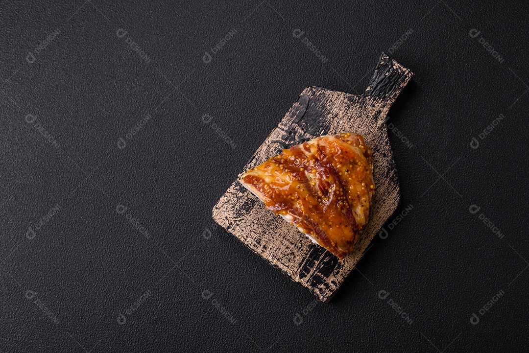 Delicioso presunto ou carne de frango com sal, especiarias e mostarda francesa sobre um fundo escuro de concreto