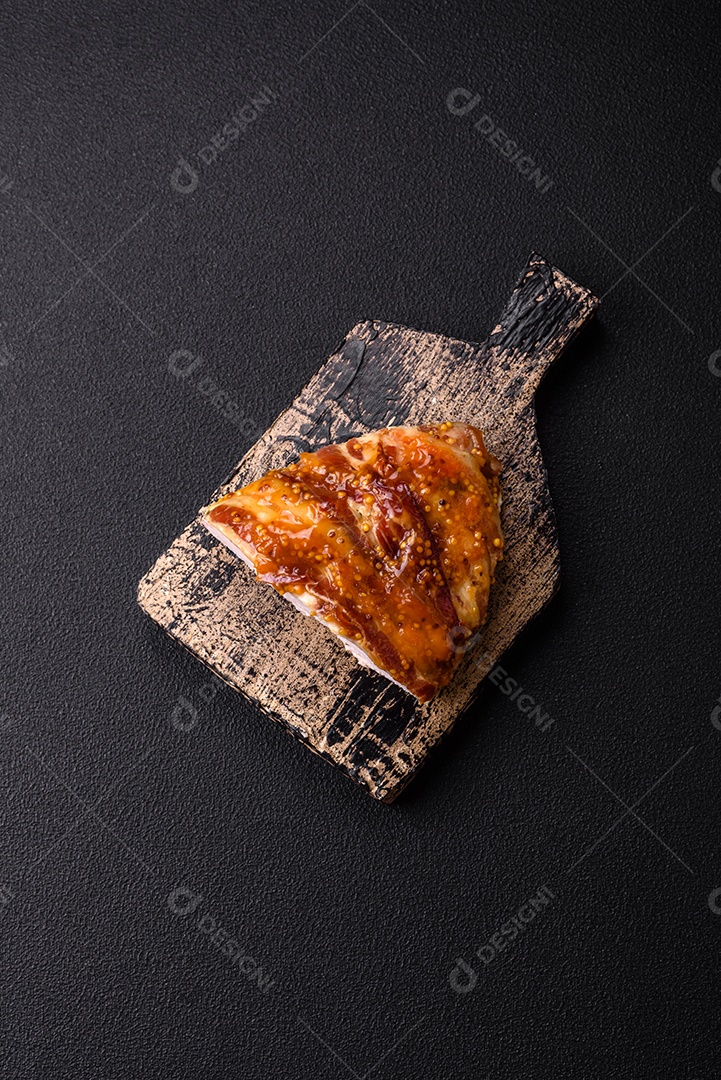 Delicioso presunto ou carne de frango com sal, especiarias e mostarda francesa sobre um fundo escuro de concreto