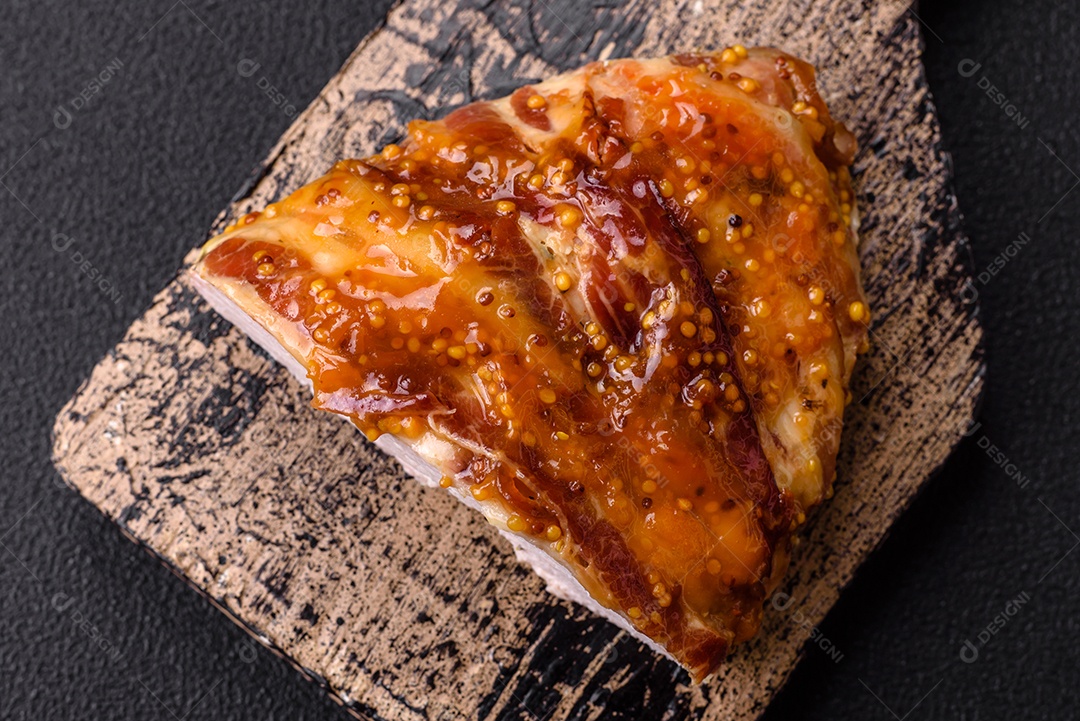 Delicioso presunto ou carne de frango com sal, especiarias e mostarda francesa sobre um fundo escuro de concreto