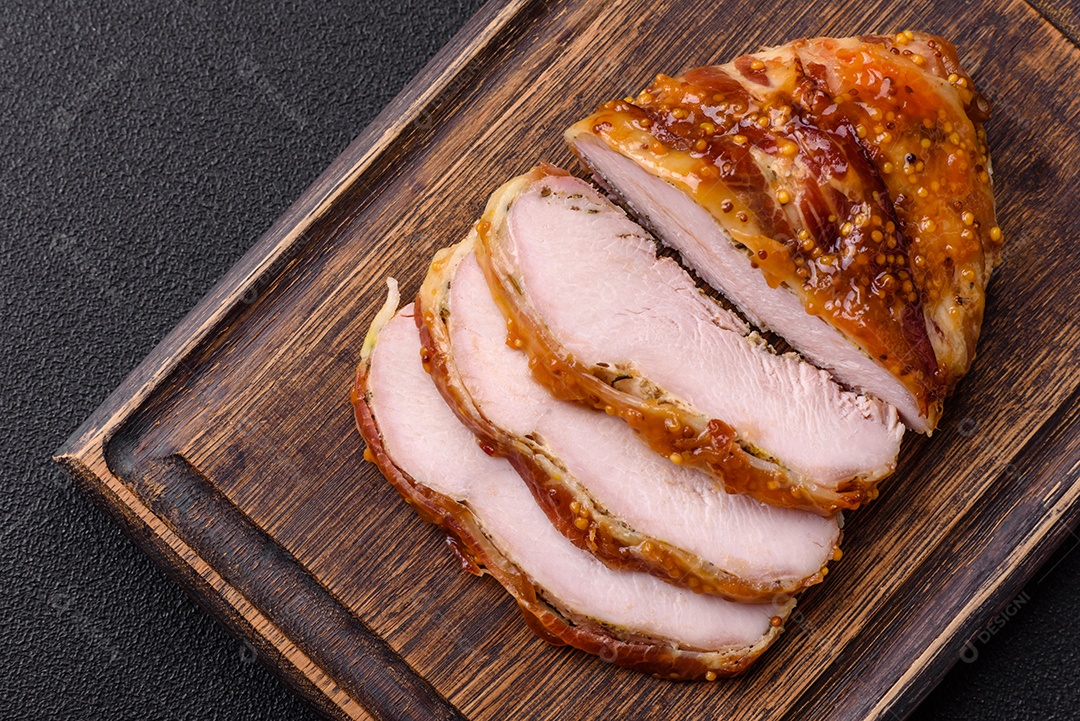 Delicioso presunto ou carne de frango com sal, especiarias e mostarda francesa sobre um fundo escuro de concreto