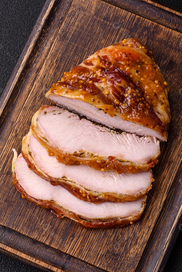 Delicioso presunto ou carne de frango com sal, especiarias e mostarda francesa sobre um fundo escuro de concreto