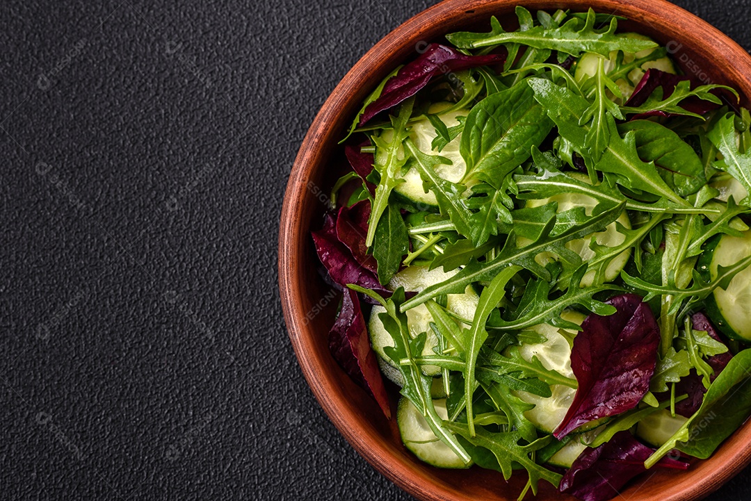Deliciosa salada suculenta com salmão, tomate, pepino, ervas, sementes de abóbora, sal e especiarias em uma placa cerâmica sobre um fundo escuro de concreto