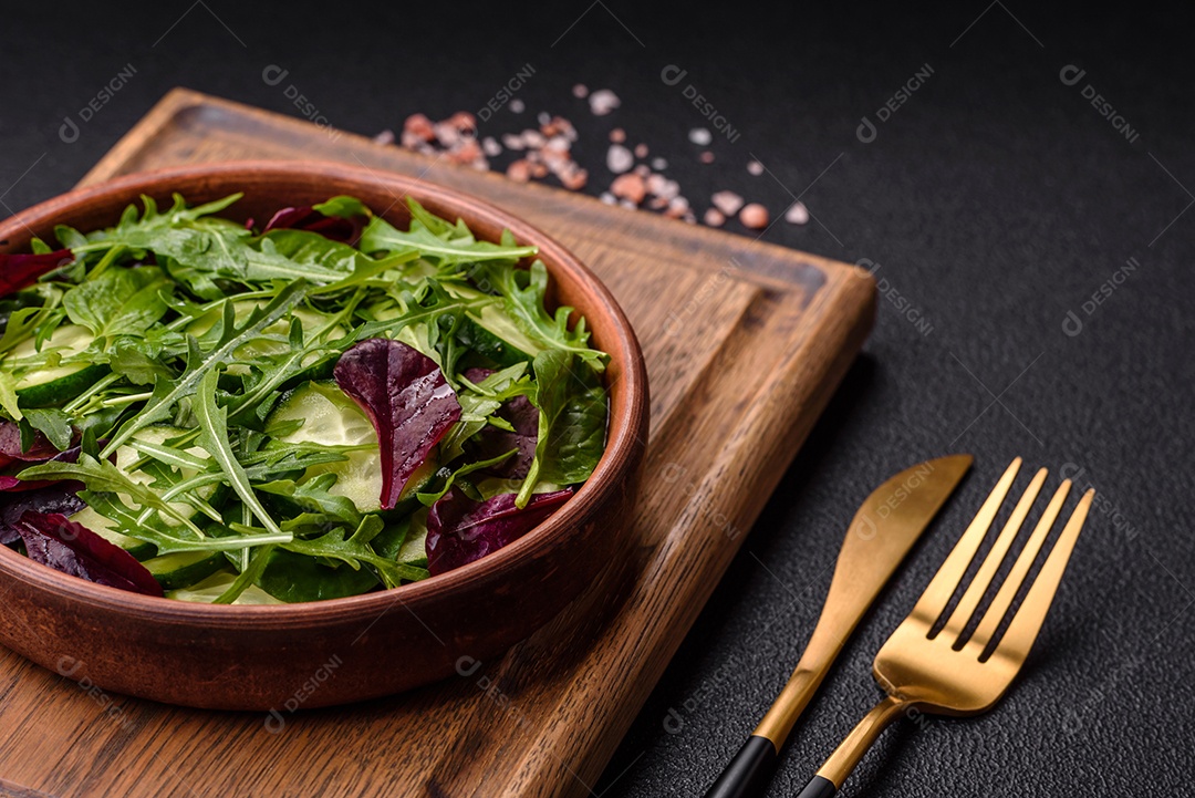 Deliciosa salada suculenta com salmão, tomate, pepino, ervas, sementes de abóbora, sal e especiarias em uma placa cerâmica sobre um fundo escuro de concreto