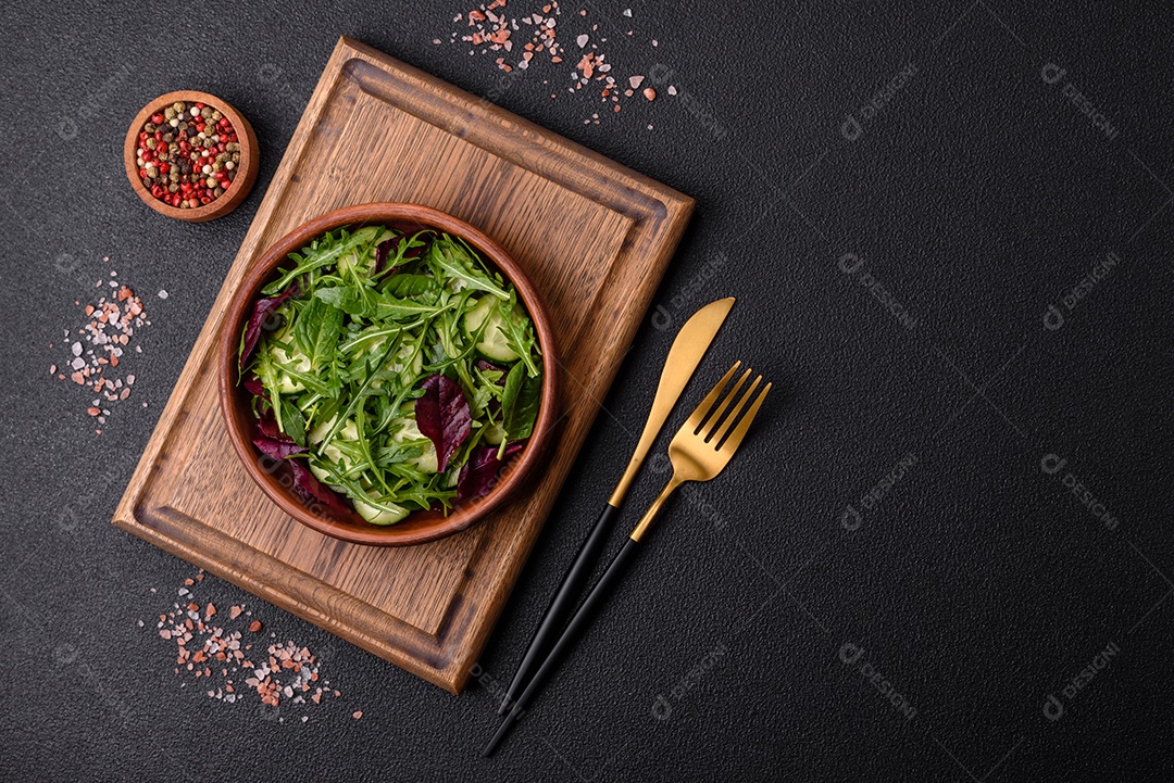 Deliciosa salada suculenta com salmão, tomate, pepino, ervas, sementes de abóbora, sal e especiarias em uma placa cerâmica sobre um fundo escuro de concreto