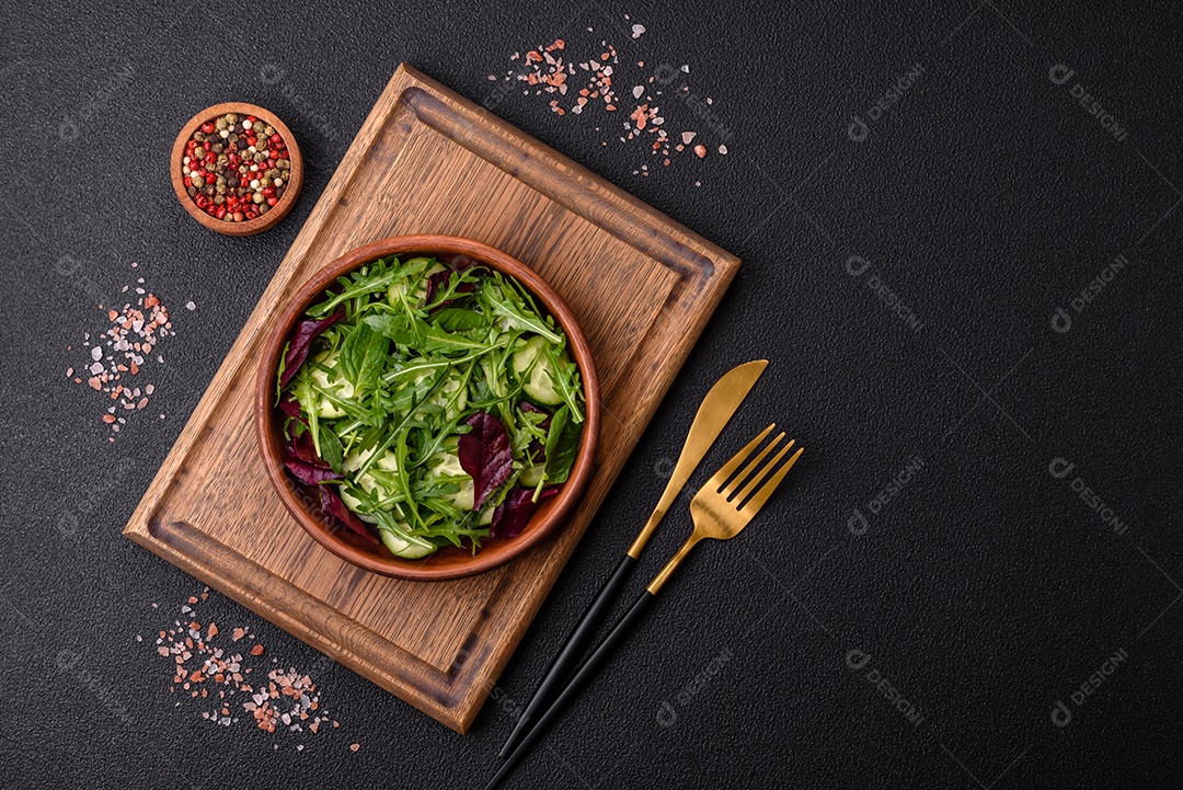 Deliciosa salada suculenta com salmão, tomate, pepino, ervas, sementes de abóbora, sal e especiarias em uma placa cerâmica sobre um fundo escuro de concreto