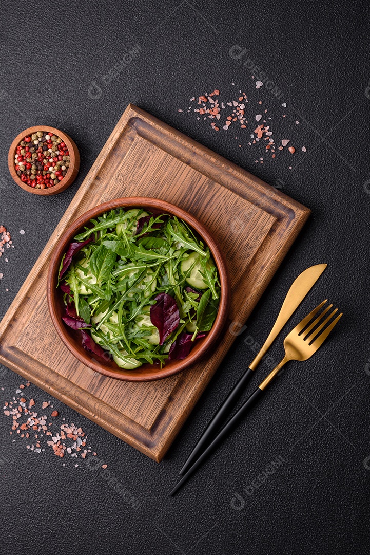 Deliciosa salada suculenta com salmão, tomate, pepino, ervas, sementes de abóbora, sal e especiarias em uma placa cerâmica sobre um fundo escuro de concreto