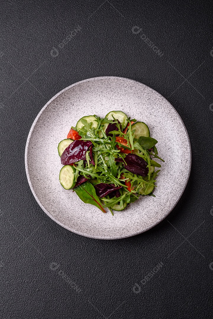 Deliciosa salada suculenta com salmão, tomate, pepino, ervas, sementes de abóbora, sal e especiarias em uma placa cerâmica sobre um fundo escuro de concreto