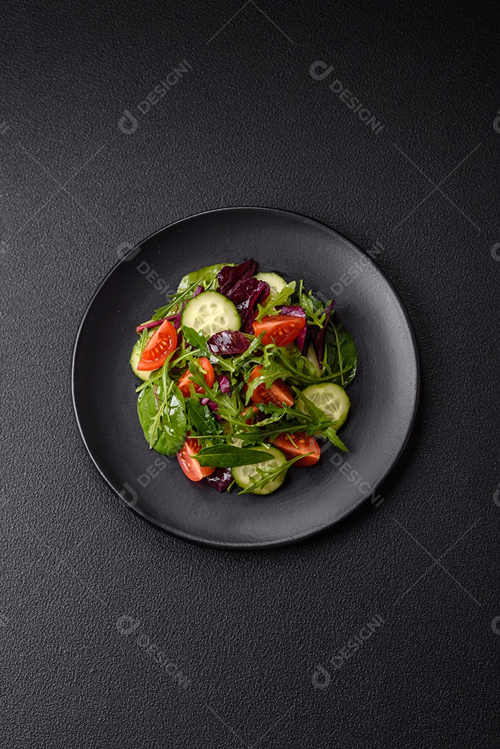 Deliciosa salada suculenta com salmão, tomate, pepino, ervas, sementes de abóbora, sal e especiarias em uma placa cerâmica sobre um fundo escuro de concreto