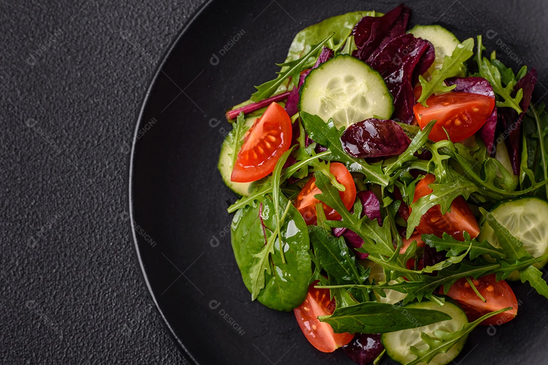 Deliciosa salada suculenta com salmão, tomate, pepino, ervas, sementes de abóbora, sal e especiarias em uma placa cerâmica sobre um fundo escuro de concreto