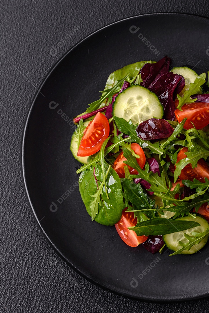 Deliciosa salada suculenta com salmão, tomate, pepino, ervas, sementes de abóbora, sal e especiarias em uma placa cerâmica sobre um fundo escuro de concreto