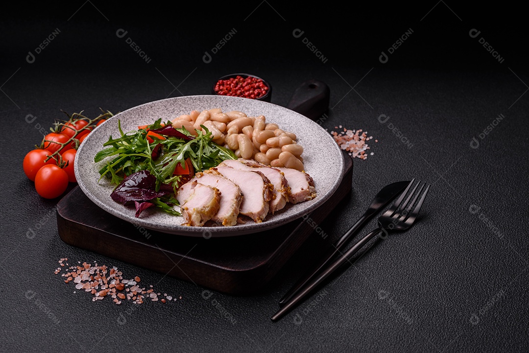 Deliciosa salada suculenta com salmão, tomate, pepino, ervas, sementes de abóbora, sal e especiarias em uma placa cerâmica sobre um fundo escuro de concreto