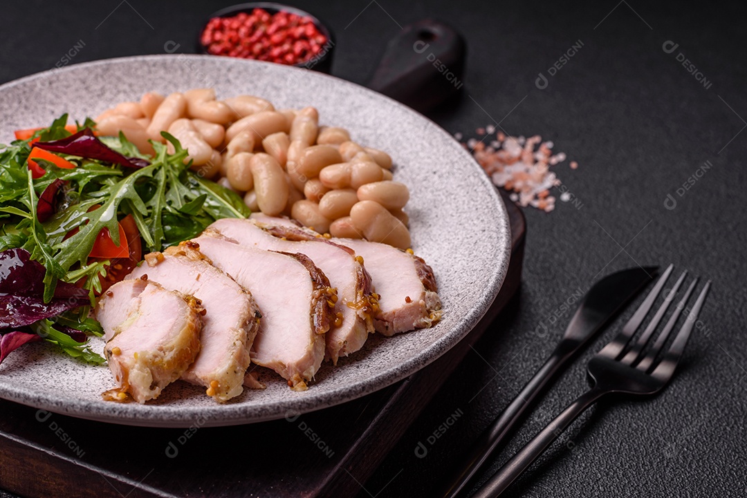 Deliciosa salada suculenta com salmão, tomate, pepino, ervas, sementes de abóbora, sal e especiarias em uma placa cerâmica sobre um fundo escuro de concreto