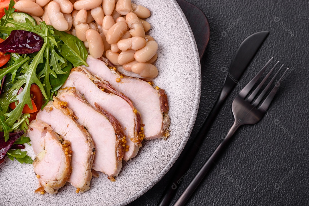Deliciosa salada suculenta com salmão, tomate, pepino, ervas, sementes de abóbora, sal e especiarias em uma placa cerâmica sobre um fundo escuro de concreto