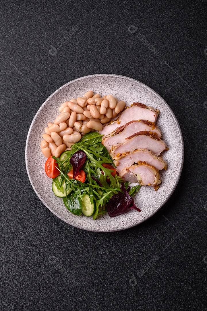 Deliciosa salada suculenta com salmão, tomate, pepino, ervas, sementes de abóbora, sal e especiarias em uma placa cerâmica sobre um fundo escuro de concreto