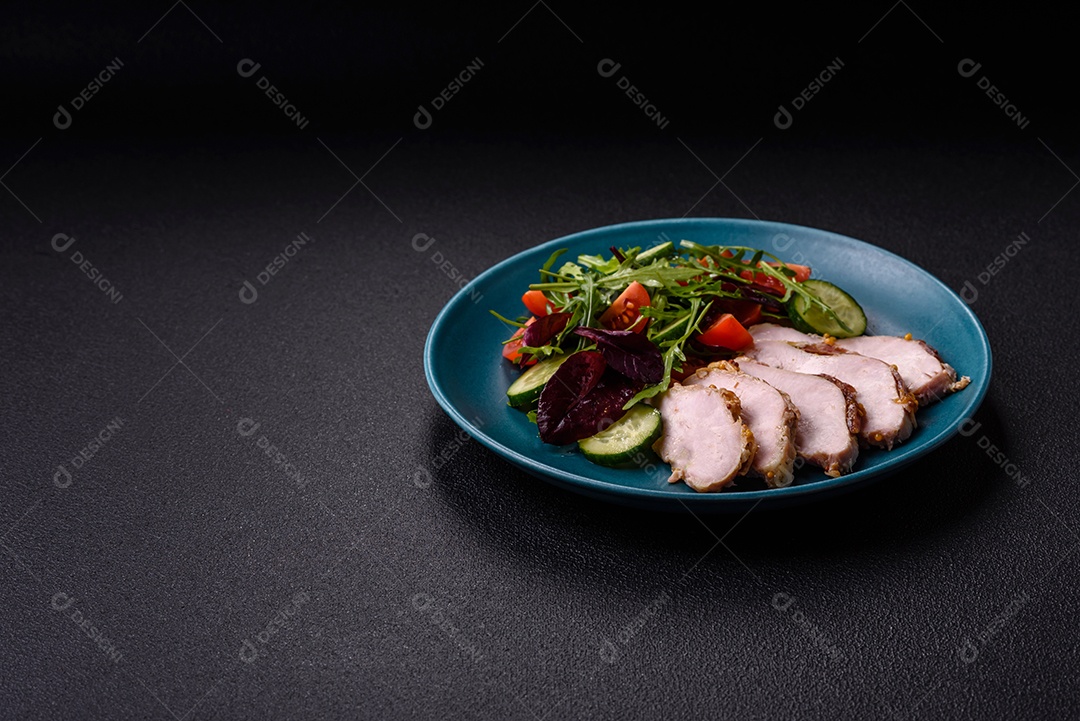 Deliciosa salada suculenta com salmão, tomate, pepino, ervas, sementes de abóbora, sal e especiarias em uma placa cerâmica sobre um fundo escuro de concreto