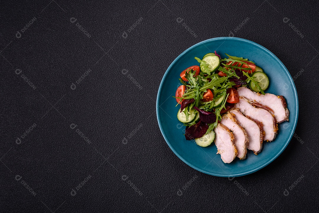 Deliciosa salada suculenta com salmão, tomate, pepino, ervas, sementes de abóbora, sal e especiarias em uma placa cerâmica sobre um fundo escuro de concreto