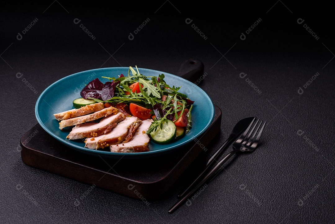 Deliciosa salada suculenta com salmão, tomate, pepino, ervas, sementes de abóbora, sal e especiarias em uma placa cerâmica sobre um fundo escuro de concreto
