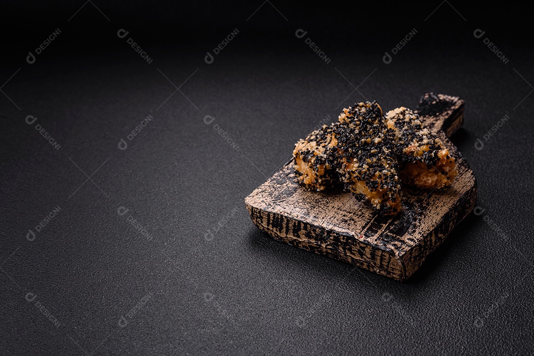 Deliciosos nuggets de frango ou peixe crocantes frescos em um fundo escuro de concreto. Alimentos não saudáveis, fast food